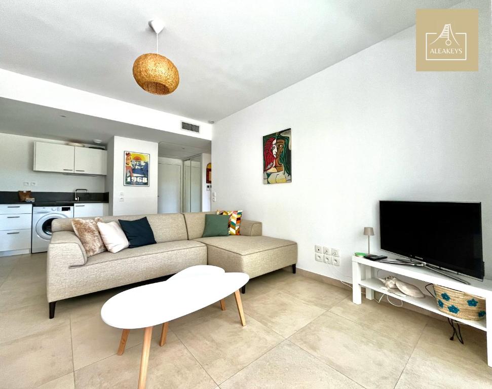 un salon avec un canapé et une télévision à écran plat dans l'établissement Le Coba Beach - P3 Cosy, Clim, Parking, Plage à 10 min à pied, à La Grande Motte