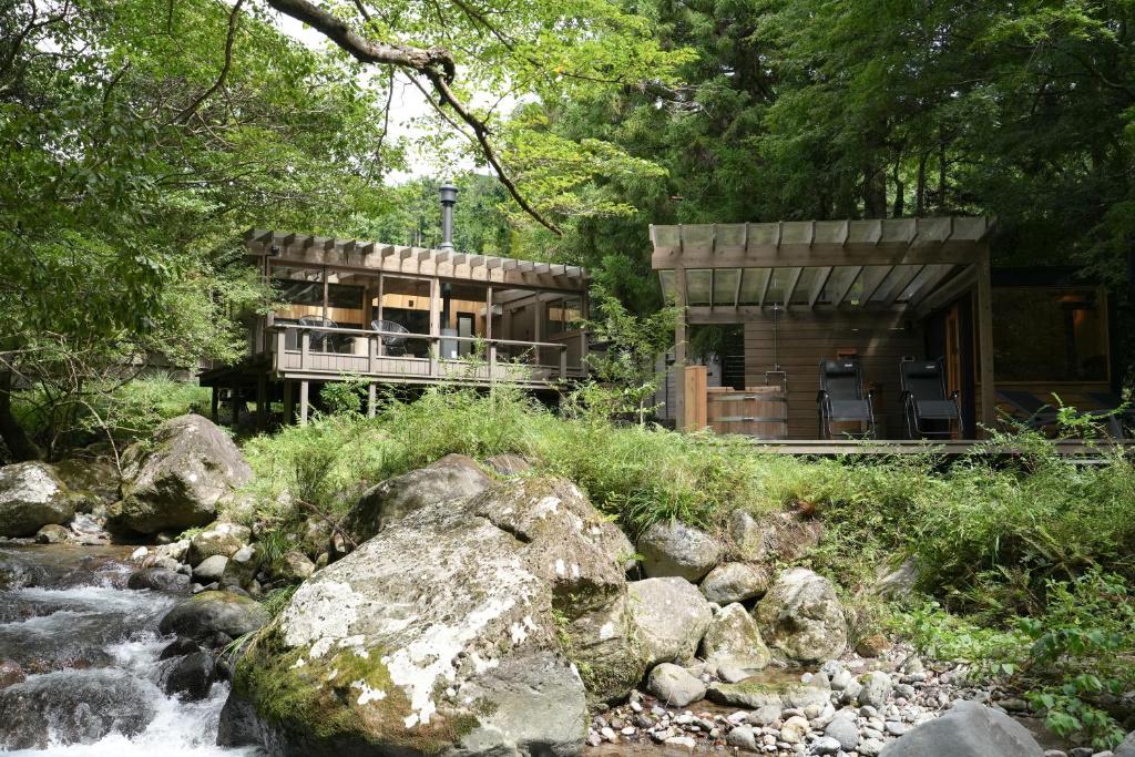 a house in the woods next to a river at Tiny Base The MOUNTAiN in Shimo-sagano