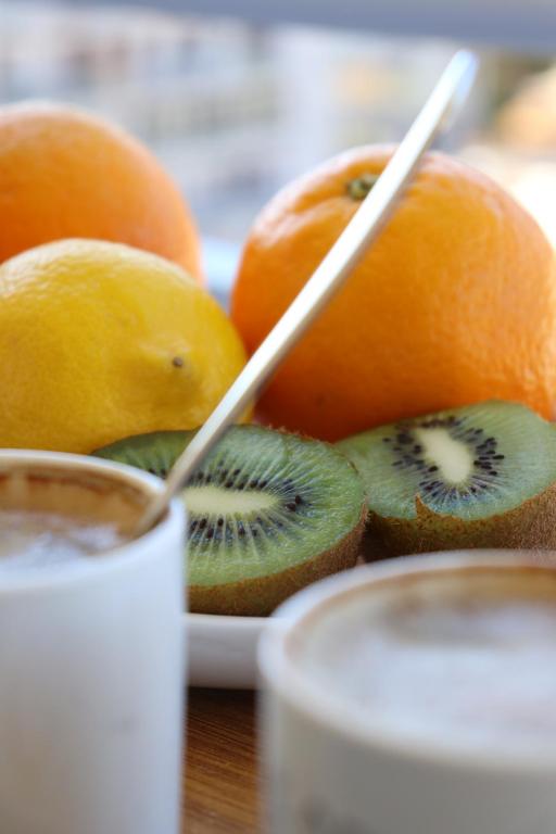 阿雅克修Spacieux Appartement Vue Mer et Montagne en dernier étage avec Terrasse - Parking et Wifi的一盘橙子和猕猴桃，配一把勺子