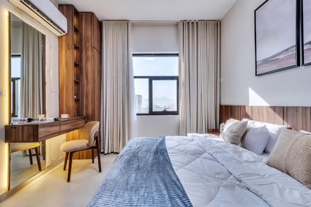 a hotel room with a bed and a desk and windows at Khorfakan by the Living in Khor Fakkan