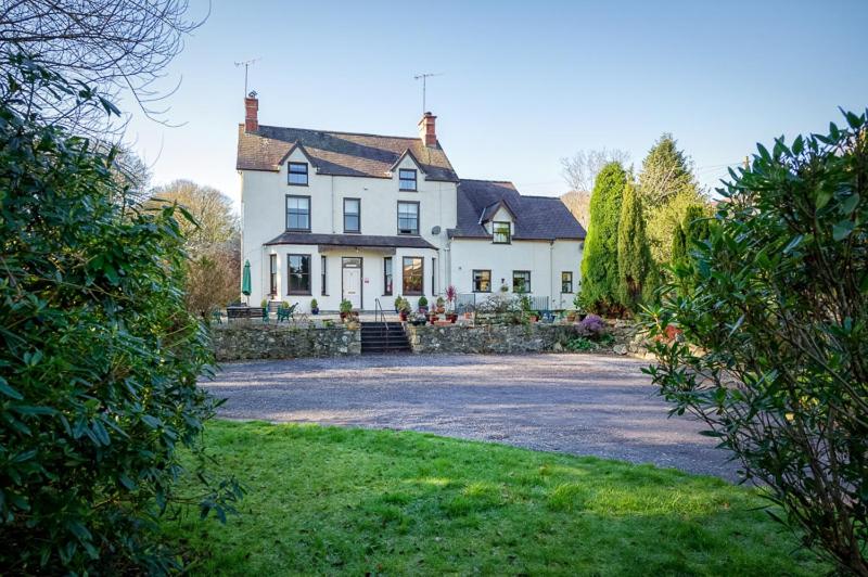 a large white house with a large driveway at Craig Y Glyn in Pwllheli