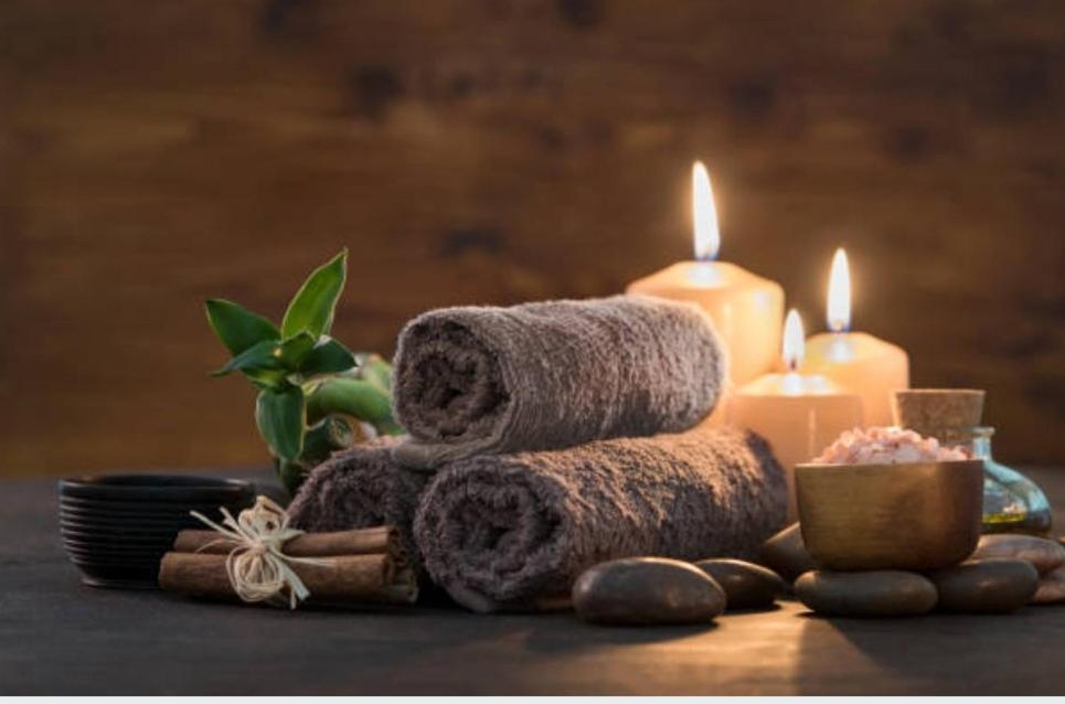 una pila de toallas y velas sobre una mesa en Villa événements Balnéo & Spa, en Villampuy