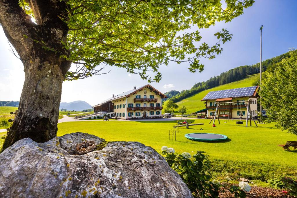 un parc avec un arbre et un bâtiment dans l'établissement Aschenauer Hof, à Ruhpolding