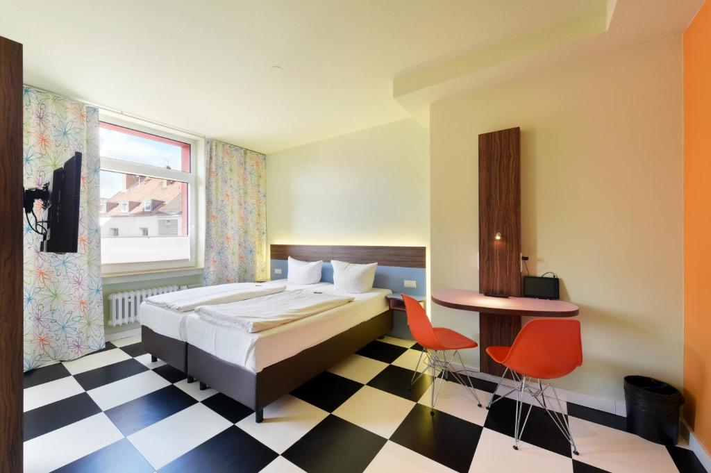 a bedroom with a bed and a checkered floor at Cityhotel Thüringer Hof Design Hannover - Self Check-In in Hannover