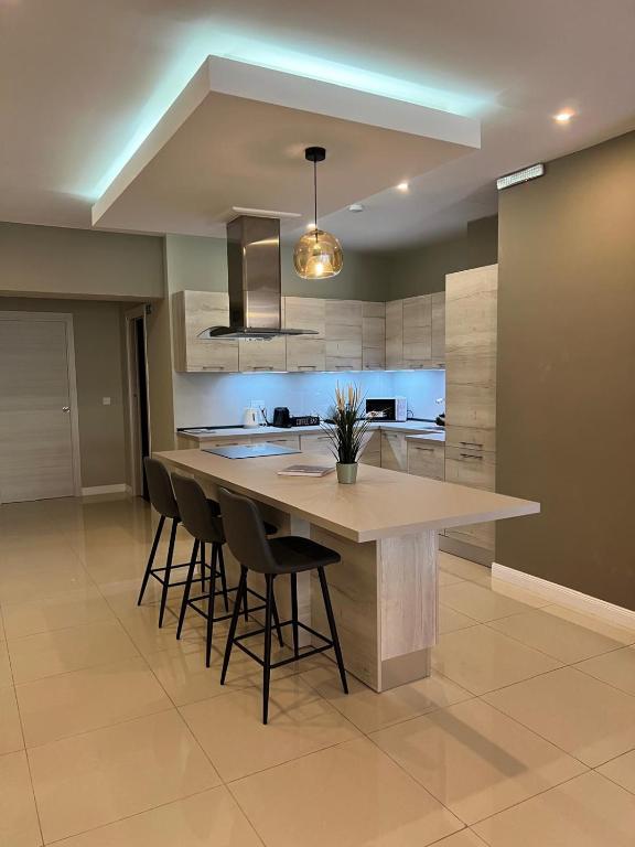 a kitchen with a large island with bar stools at Salus Holiday Apartment in Victoria