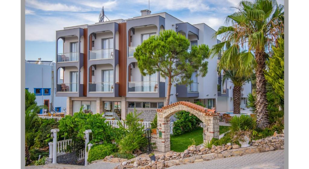 a building with palm trees in front of it at Calis Hotel in Cesme