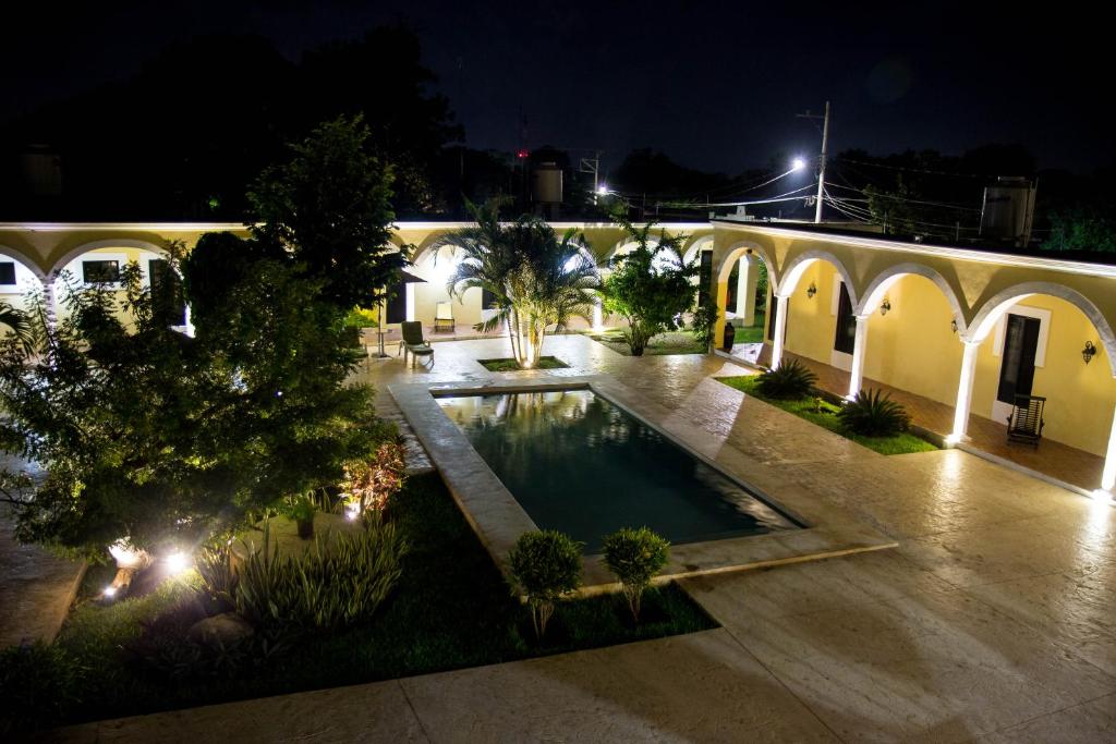 an empty courtyard with a swimming pool at night at Hotel Hacienda Izamal in Izamal