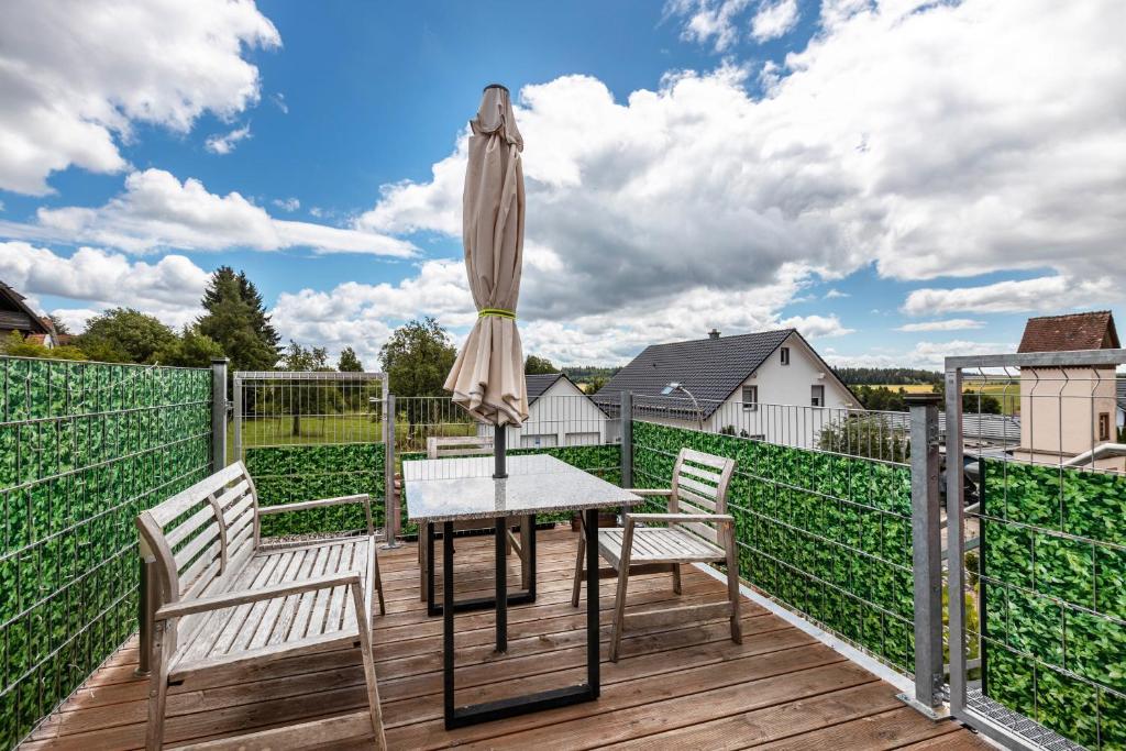 BräunlingenにあるApartment Malsamのテーブルと椅子と傘のあるパティオ