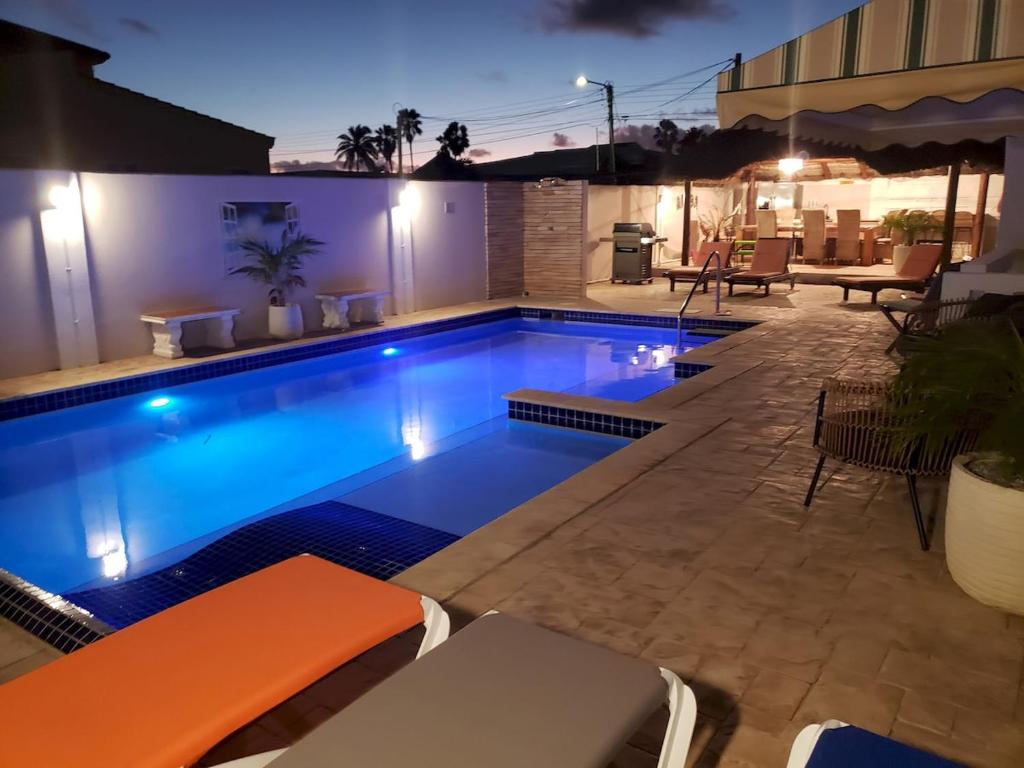 a swimming pool in a backyard at night at Villa de Leon suitable for 14 persons. 5 bedrooms 5 bathrooms in Palm-Eagle Beach