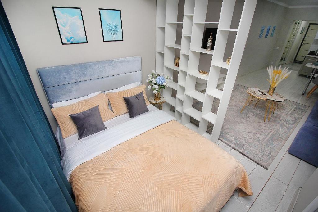 a bedroom with a large bed in a room at Arbat Central Apartment in Almaty
