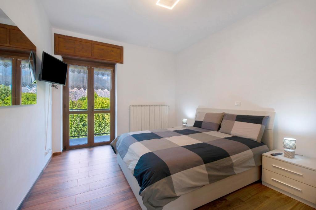 a bedroom with a bed and a television in it at Welcome Home 2 vista Rocciamelone in Meana di Susa