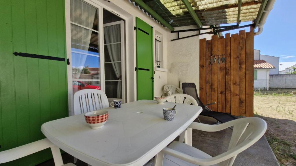 une table et des chaises sur une terrasse avec un mur vert dans l'établissement St Georges de Didonne - MAISON en plein CENTRE-VILLE - PROCHE PLAGE, à Saint-Georges-de-Didonne