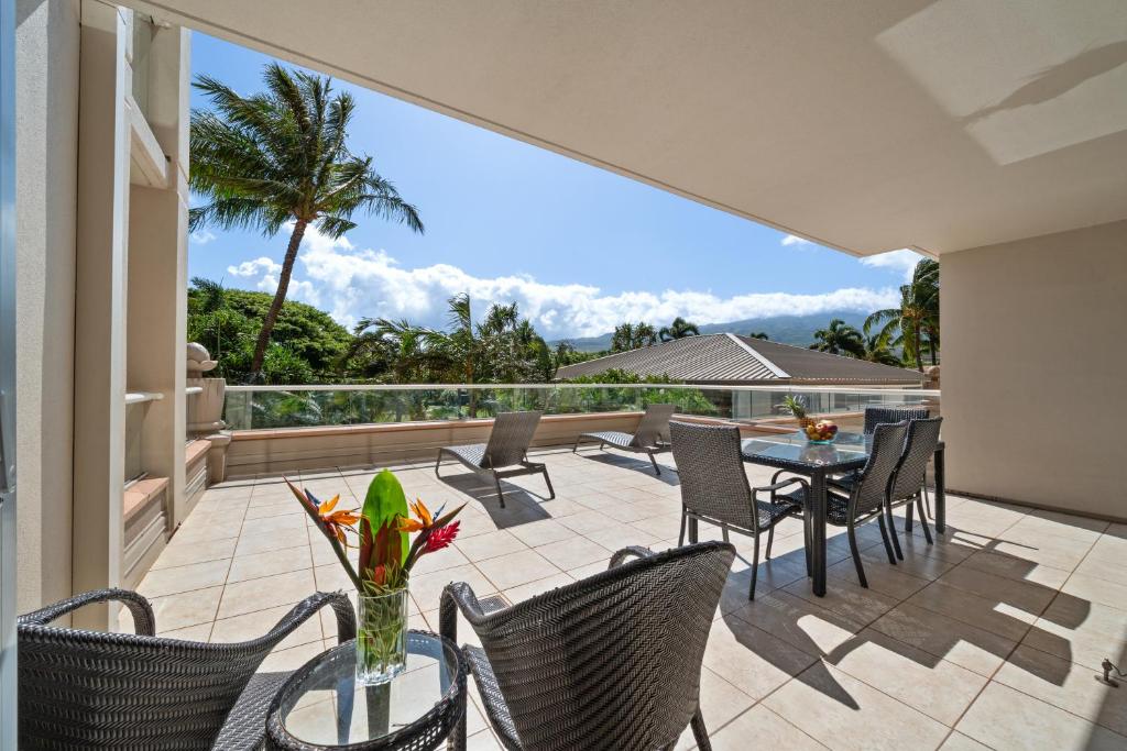 a patio with a table and chairs on a balcony at Honua Kai Konea 230 in Kahana