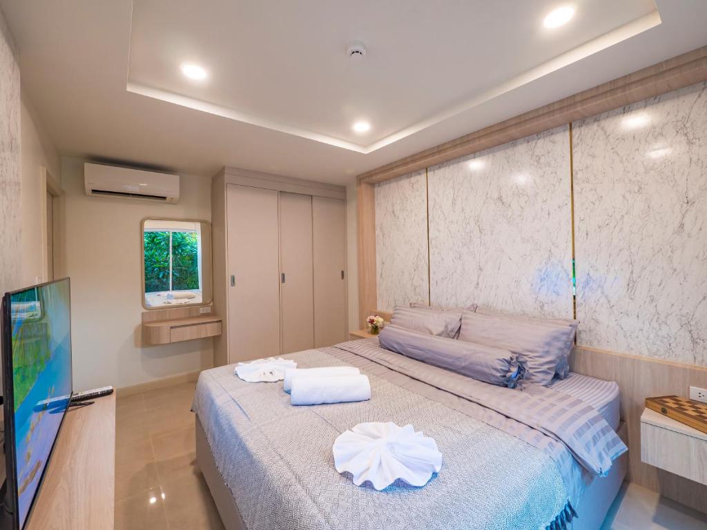 a bedroom with a bed and a flat screen tv at Lamai Beach - Apartment Leo in Nathon Bay
