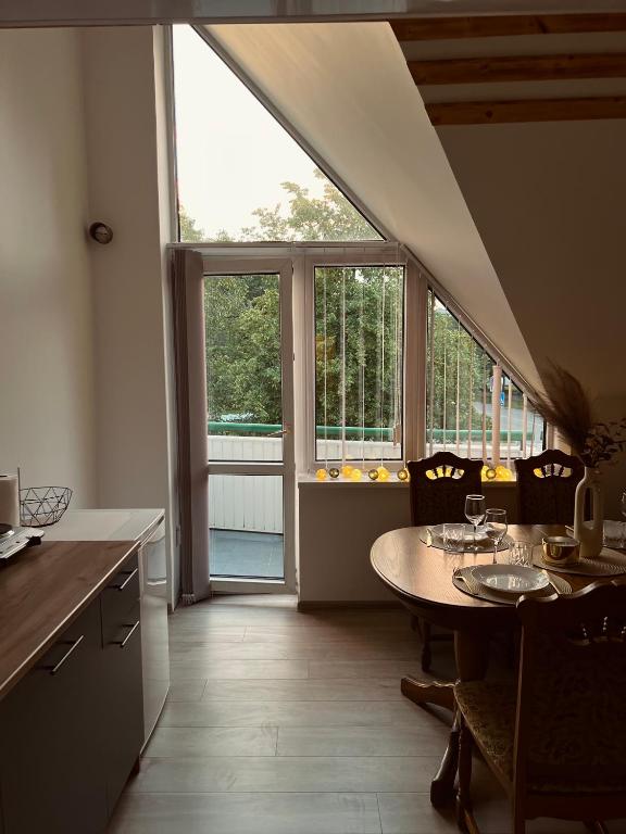 eine Küche mit einem Tisch und einem großen Fenster in der Unterkunft Saulėlydžio apartamentai in Palanga
