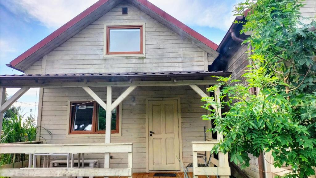 una casa pequeña con porche y puerta en Domki Pirat, en Władysławowo