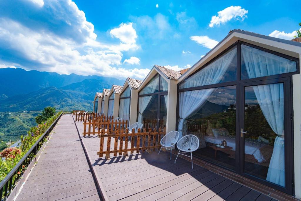 una terraza con sillas y mesas en la cima de una montaña en Mây ơi homestay- Venuestay, en Sa Pa