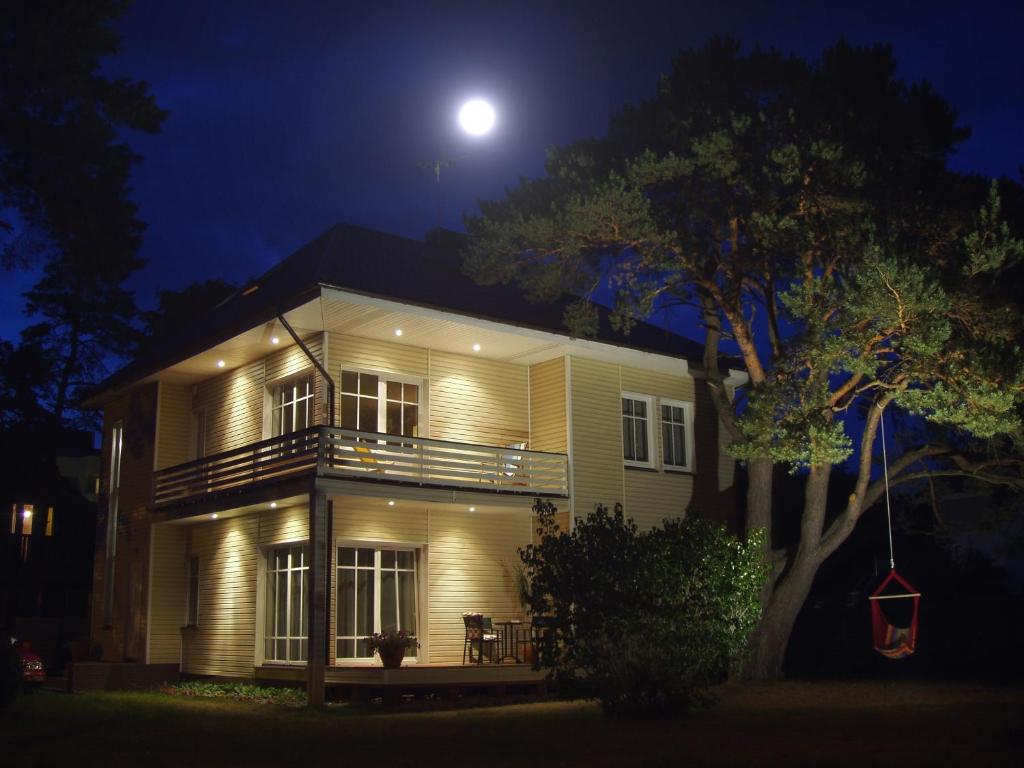 a house at night with the moon in the sky at Vila Claudia in Palanga