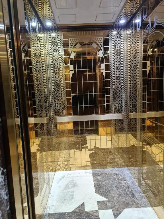 a man behind a glass door in a wine cellar at Manazel Al Taqwa Hotel in Quai
