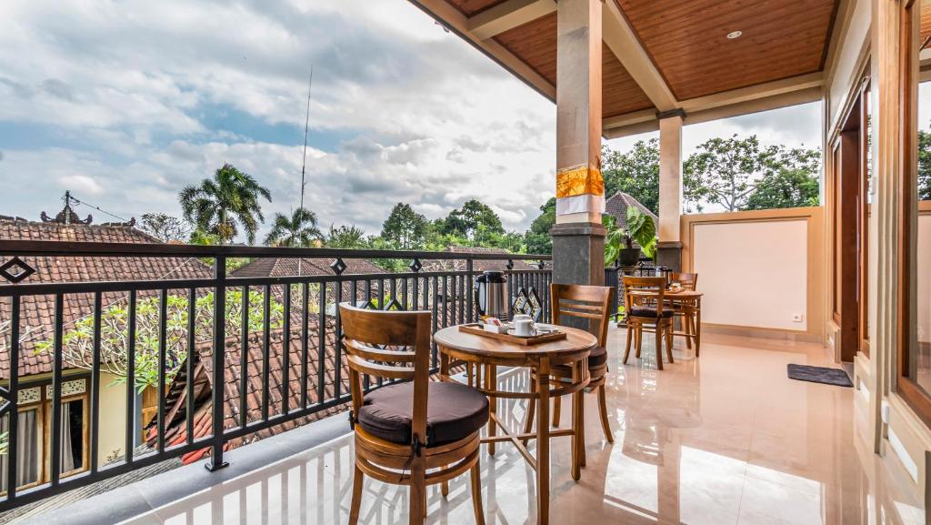 a balcony with a table and chairs on it at Usana House Ubud in Ubud