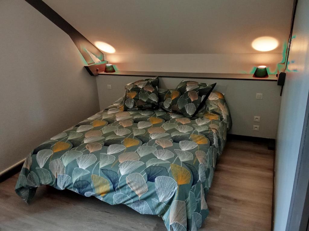 a bedroom with a bed with a colorful comforter at la passerelle in Maurs