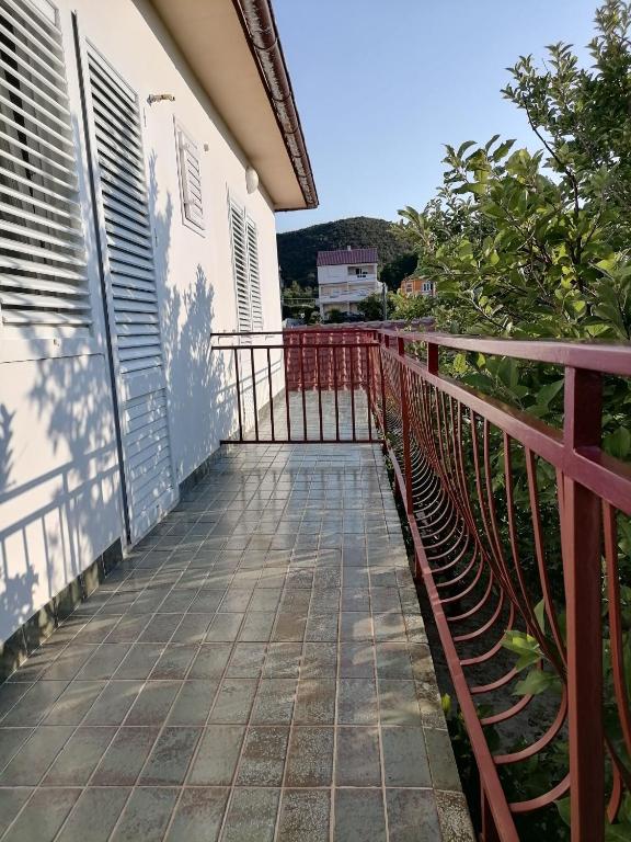 a balcony of a house with a red fence at Apartments Poldan in Supetarska Draga
