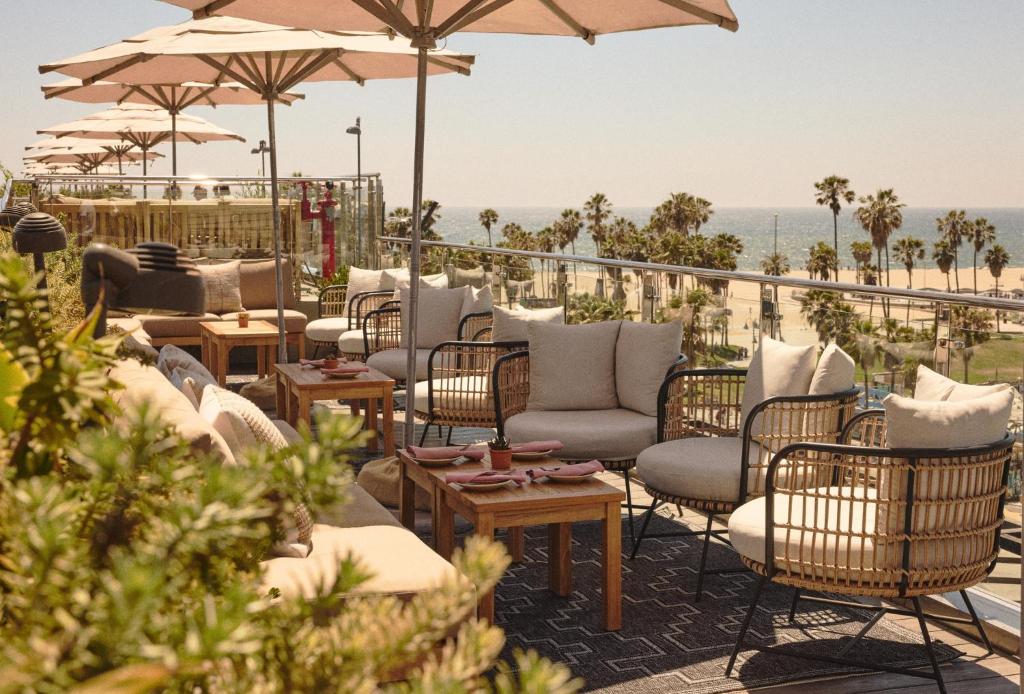 a patio with chairs and tables and umbrellas at Hotel Erwin Venice Beach in Los Angeles