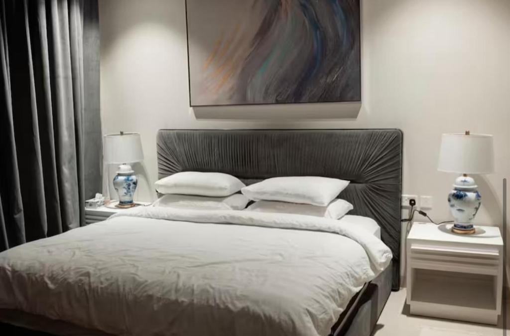 マスカットにあるNight Moonのベッド、ナイトスタンド2台、ランプ2個を備えた寝室