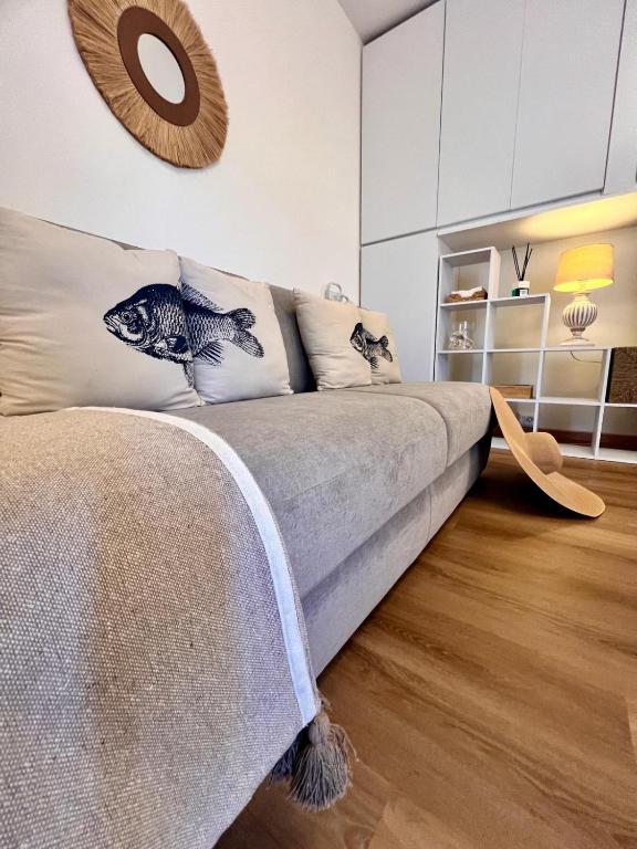 a living room with a couch with pillows on it at Casa della Conchiglia Castiglioncello in Castiglioncello