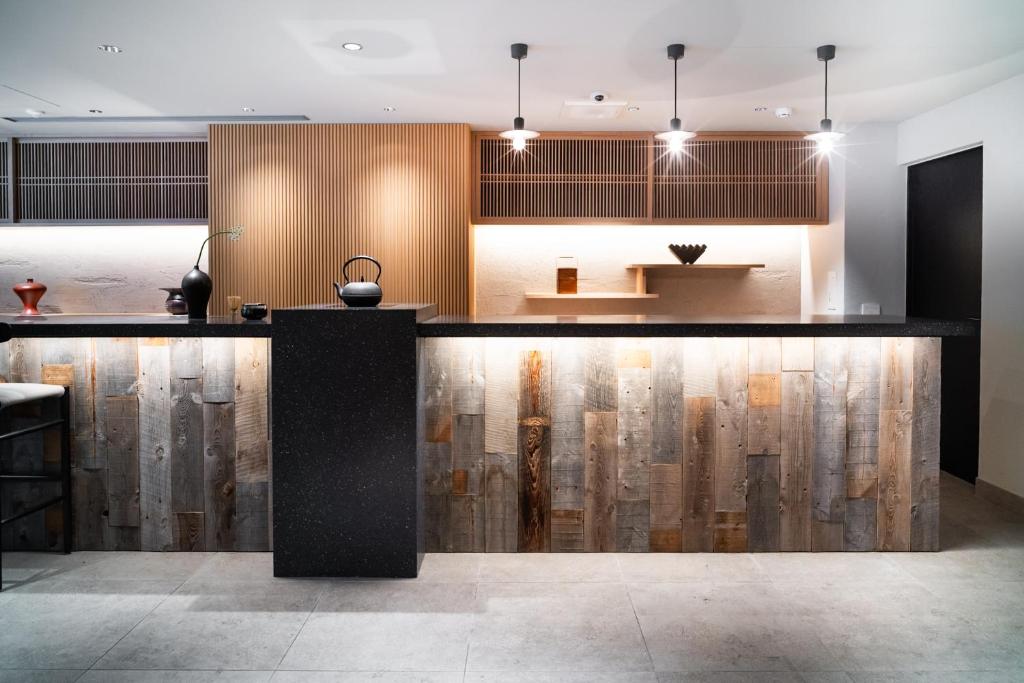 a kitchen with a black counter top and wooden cabinets at KIORI Hotel Higashino Toin in Kyoto
