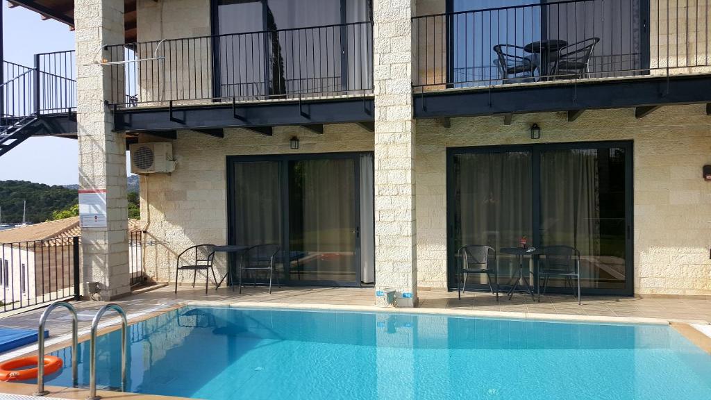 a swimming pool in front of a building at Ornella Beach Resort & Villas in Syvota
