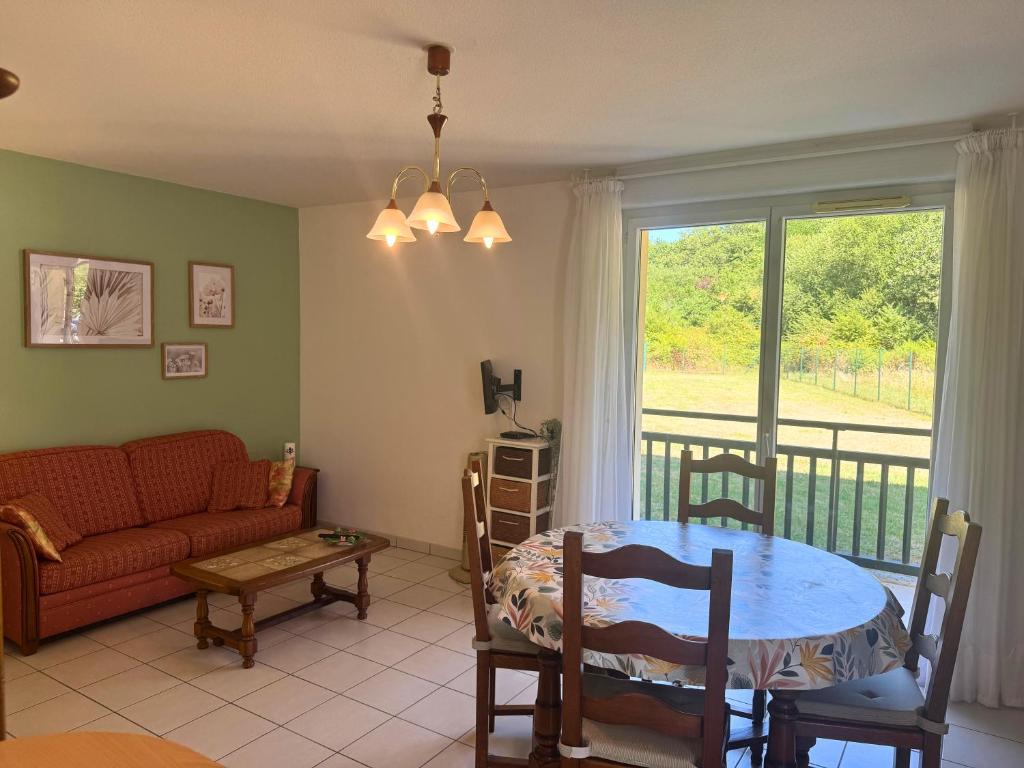 a living room with a table and a couch at Vintage - Calme - Elégant - Terrasse in Saint-Paul-lès-Dax