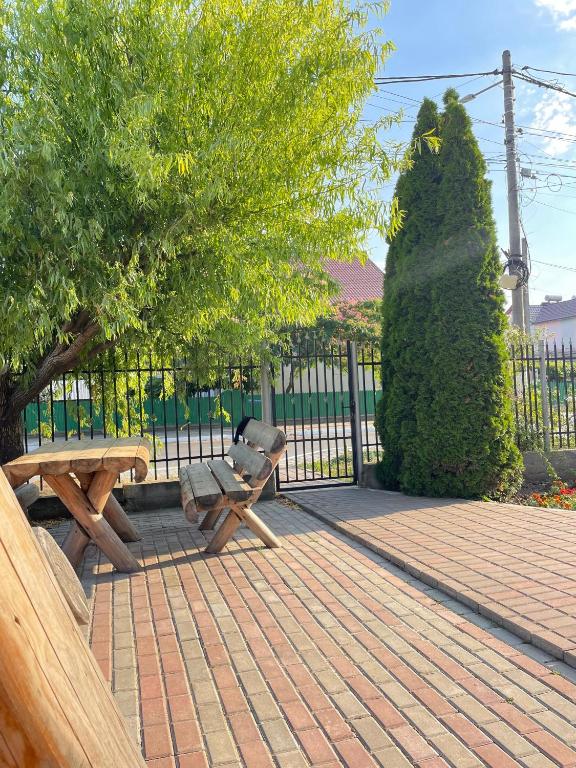 a wooden bench sitting next to a tree and a fence at Vila Pajura in Costinesti