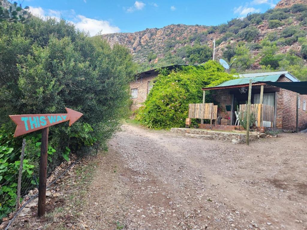 a dirt road with a sign next to a building at The Candle Cottage at Keurkloof Valley Family Farm in Uniondale