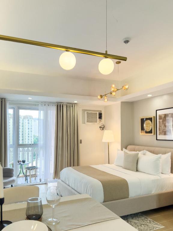 a bedroom with a large bed and a living room at Casa Elisae l Venice Grand Canal Mall Access in Manila