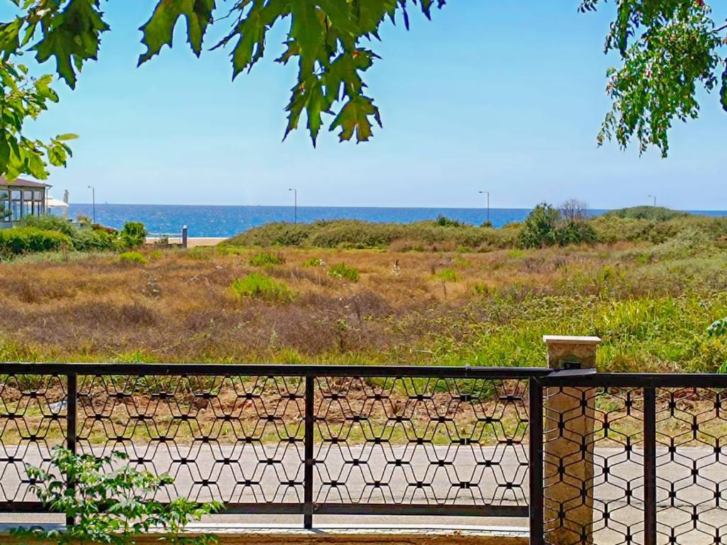 a black fence with the ocean in the background at Villa Platanos in Kanali