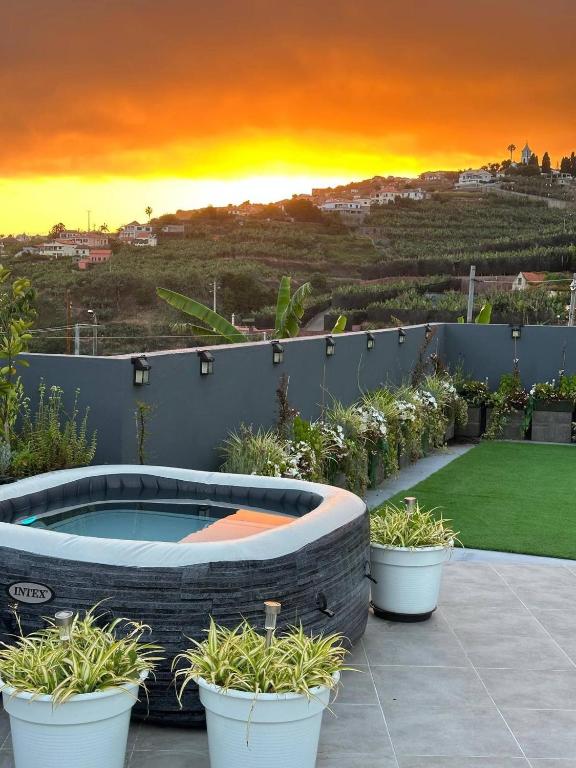 a backyard with a hot tub and potted plants at Miguels Seaview Corner in Ponta do Sol