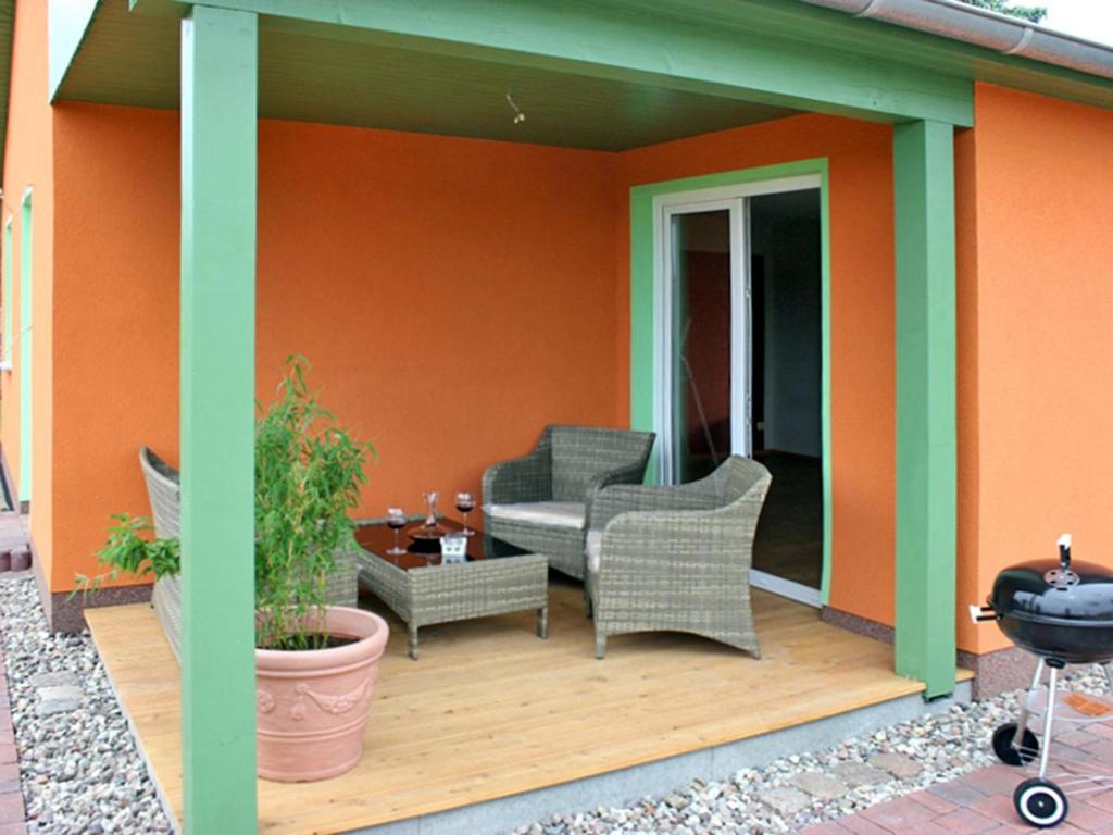 a deck with two chairs and a table on a house at kleines Ferienhaus am Feldrand in Malchow