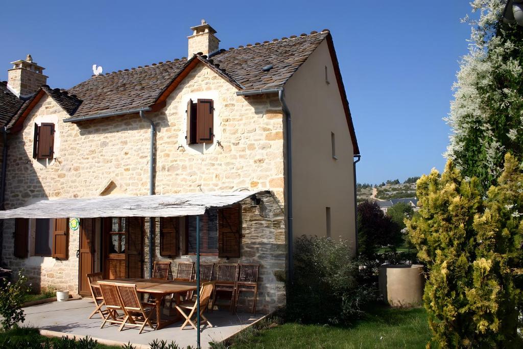 an external view of a house with a table and chairs at La Chanterelle - Gites Rocheflamme in La Malène