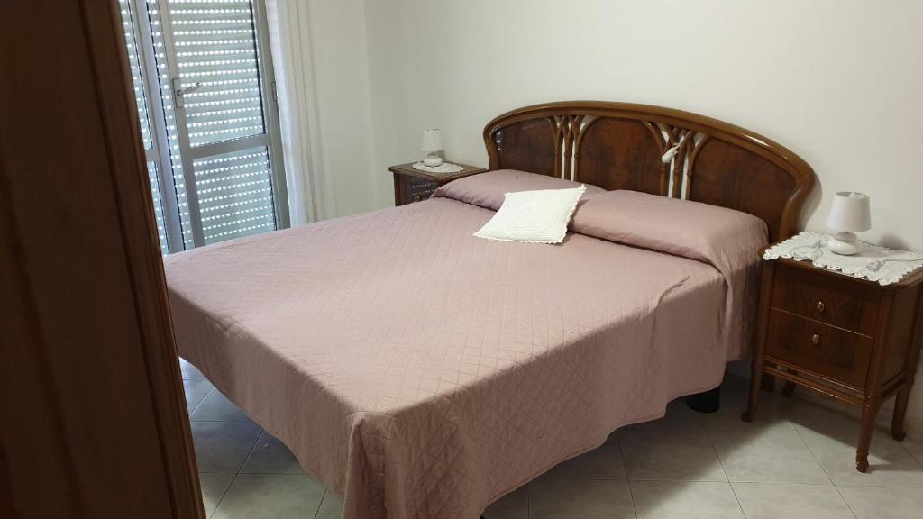 a bedroom with a bed with purple sheets and a nightstand at Ca da Simo in Albenga