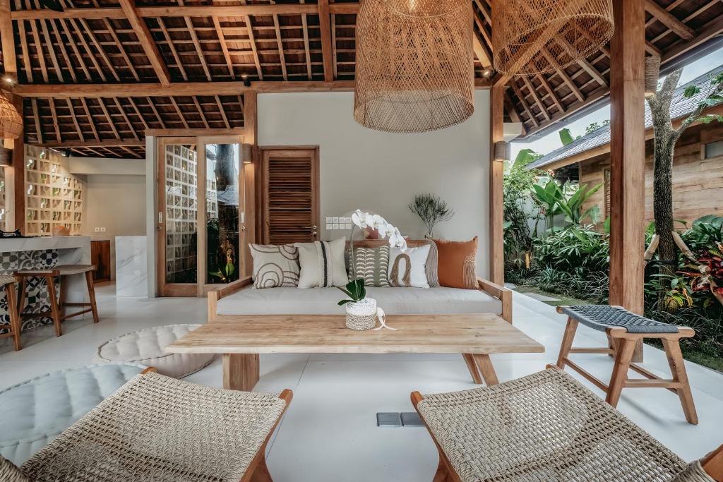 een woonkamer met een tafel en stoelen bij Kaju Villa Canggu in Canggu