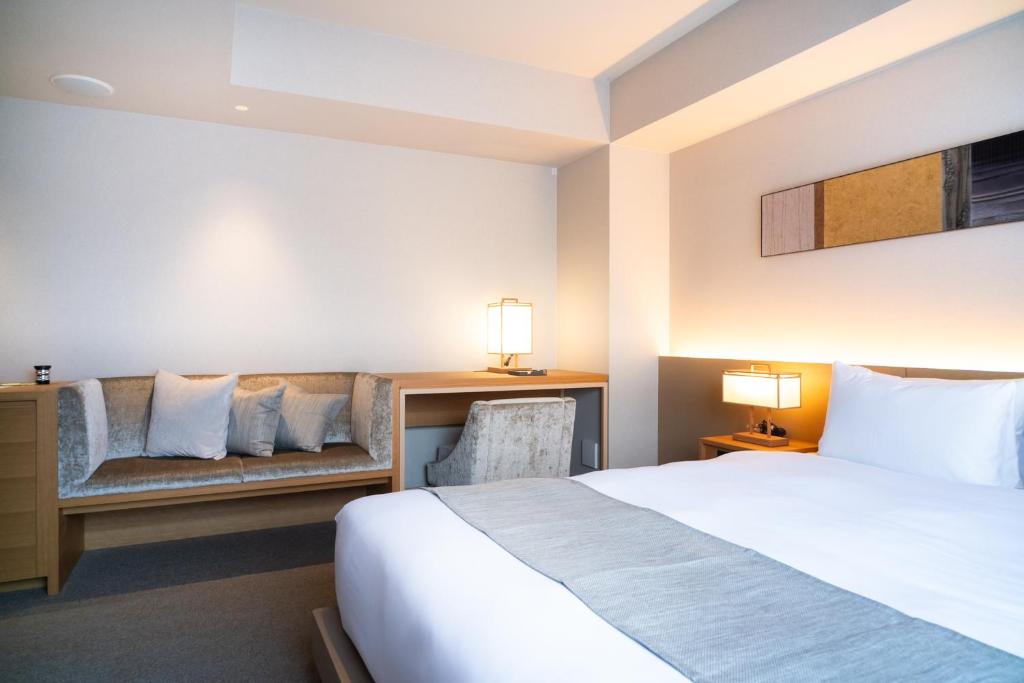 a hotel room with a bed and a couch at KIORI Hotel Takakura in Kyoto