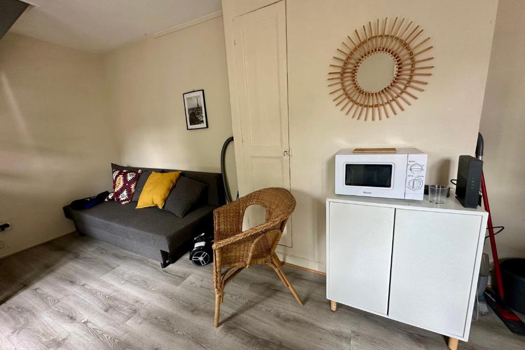 a small living room with a couch and a microwave at Duplex au centre de Fontainebleau vivez en plein cœur de la ville in Fontainebleau