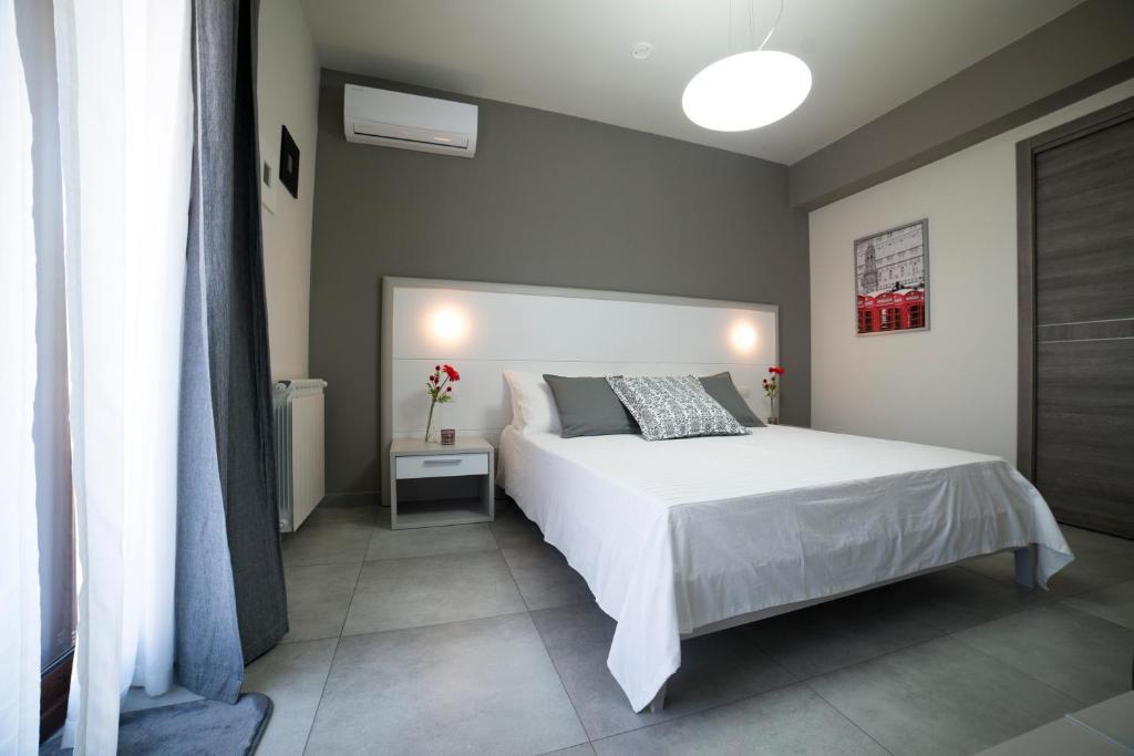 1 dormitorio con cama blanca y ventana en Sikania Casa Diamond en Messina