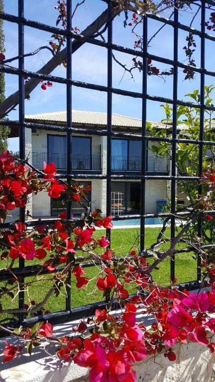 a bunch of red flowers in front of a building at Ornella Beach Resort & Villas in Syvota