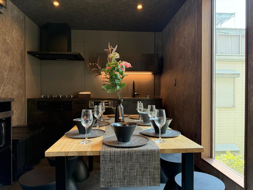a table with wine glasses and a vase with flowers at EKVOLI ROPPONGI TOKYO, Private Hotel in Tokyo