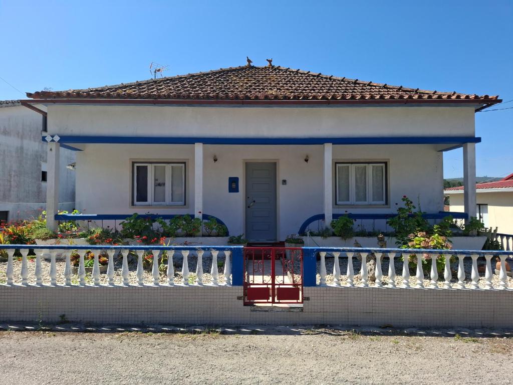 a house with a blue and white fence at Casa do Vale in Arrabal