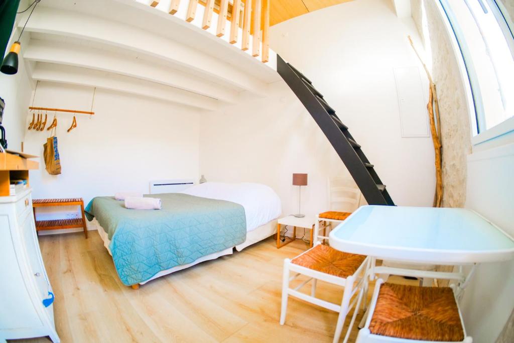 une chambre avec un lit, une table et un lavabo dans l'établissement Joli studio au calme au cœur des Sables d'Olonne - 4 personnes, à Les Sables-dʼOlonne