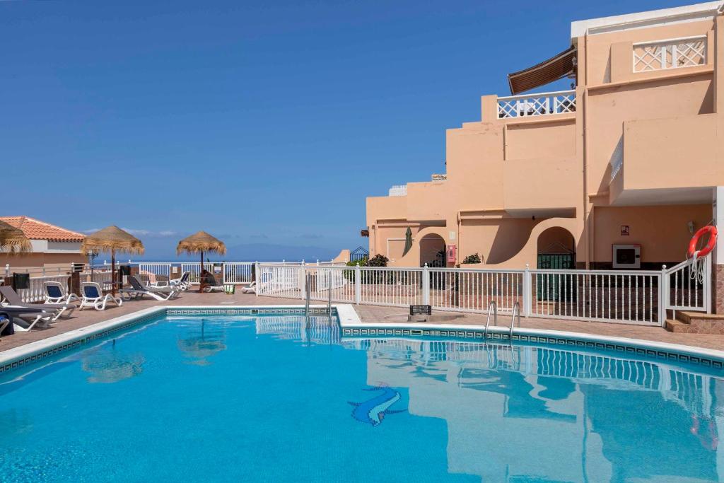 a swimming pool in front of a building at Paradise Court 1 BR Condo with Pool, Costa Adeje in Adeje