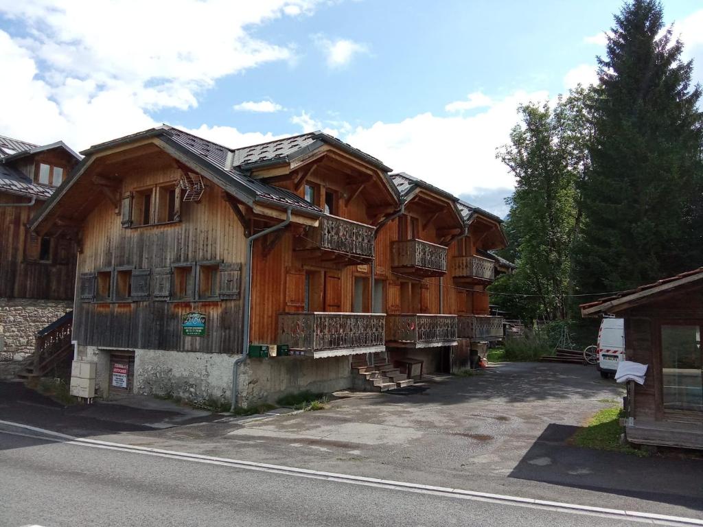Cette grande maison en bois possède de nombreuses fenêtres. dans l'établissement Le tenneverge, à Morillon
